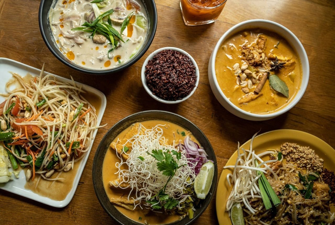 Curry tailandés. Foto: <a href="https://unsplash.com/@alexgoesglobal?utm_source=Hoy%20Apps&utm_medium=referral" target="_blank" rel="noopener">Alexandra Tran</a> (<a href="https://unsplash.com/photos/a-wooden-table-topped-with-plates-of-food-VW0bzb90oMA?utm_source=Hoy%20Apps&utm_medium=referral" target="_blank" rel="noopener">Unsplash</a>)